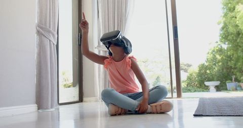 Young Girl Engaging with Virtual Reality Headset in Bright Home
