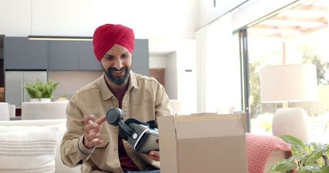 Man unboxing virtual reality headset at home with enthusiasm