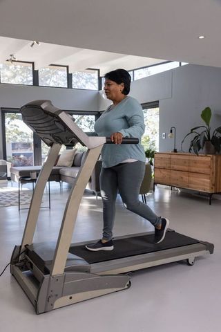 Woman Walking on Treadmill in Modern Home Interior