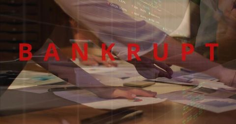Bankrupt headline over team pointing and sorting financial charts, paperwork under strain