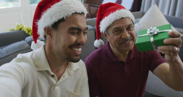 Father and Son Celebrating Christmas Holding Present in Santa Hats - Download Free Stock Images Pikwizard.com