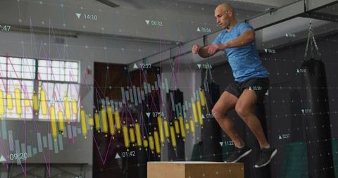 Male athlete performing plyometric box jump with fitness analytics overlay in gym studio