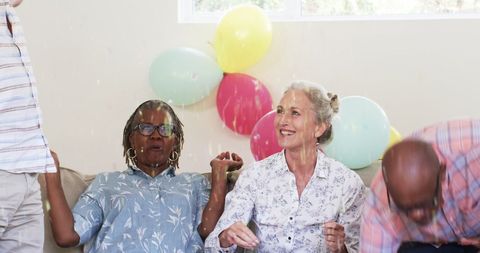 Senior Friends Celebrating Joyful Party at Home with Balloons