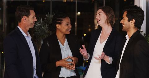 Diverse professionals smiling and conversing at corporate event