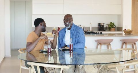 African American Father and Son Enjoying Meal in Modern Kitchen