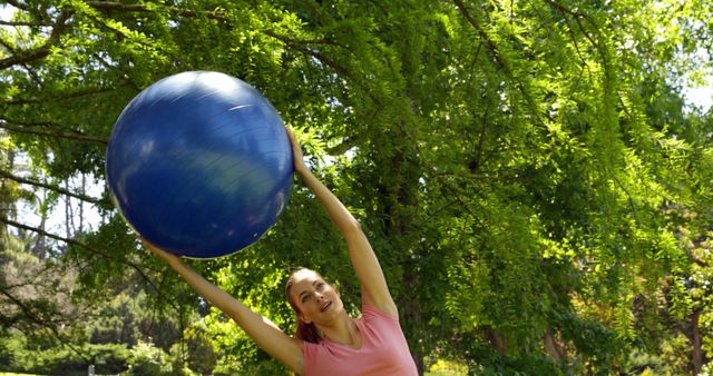 Woman Exercising with Fitness Ball Outdoors in Green Park - Download Free Stock Images Pikwizard.com