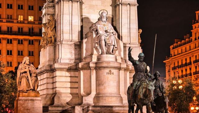 Illuminating monument featuring mounted knights on horseback, seated saint and pedestal