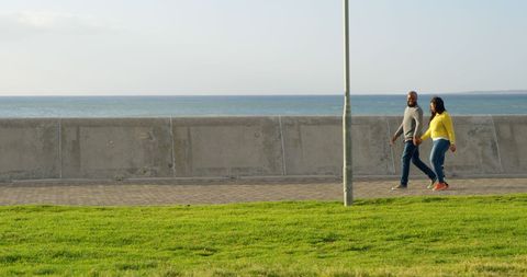Happy couple strolling on a sunny seaside promenade