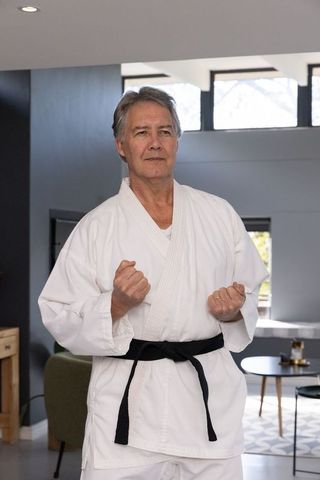 Mature Black Belt Practicing Martial Arts Indoors