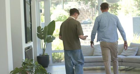 Walking parent and teen through sunlit living room toward garden