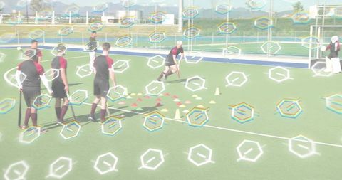 Field hockey player dribbling through cone drill leading teammates in outdoor training