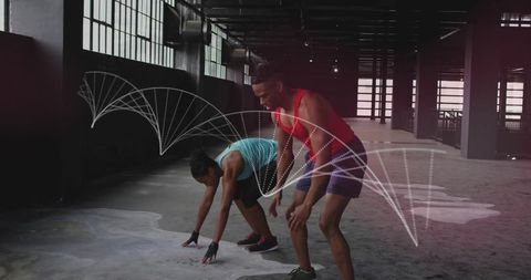 Crouching workout partners training in industrial warehouse gym with motion arc overlay