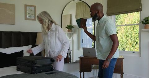 Couple Packing Suitcase for Travel Adventure in Modern Bedroom