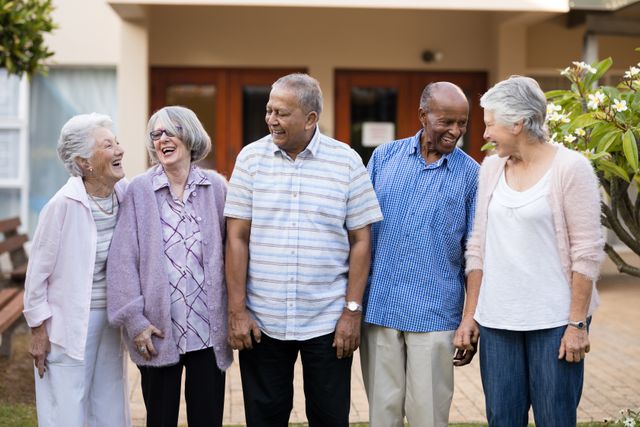 Cheerful senior men and women standing at retirement nursing home
