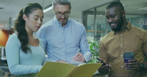 Professional team collaborating on project in open-plan office