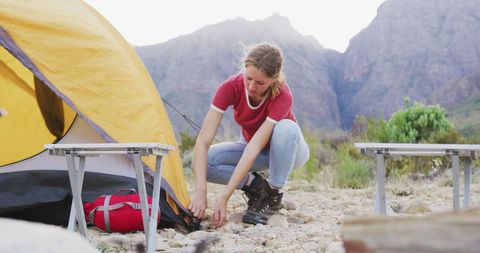 Woman Setting Up Tent in Mountainous Outdoor Adventure