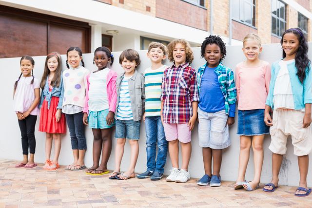 Group of happy kids standing in a row on school terrace