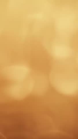 Vertical Golden Bokeh Shift: Soft Amber Orbs and Slow Focus Shimmer for Background Video