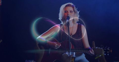 Vibrant Teen Musician Performing on Stage with Guitar