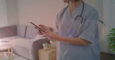 Nurse using tablet for telemedicine visit in cozy living room with stethoscope, home care