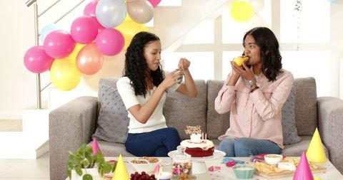 Women Celebrating Birthday with Balloons and Treats in Living Room