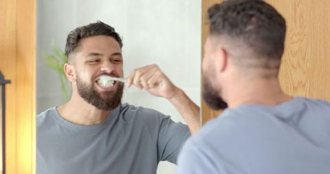 Young Man Brushing Teeth in Modern Bathroom Setting
