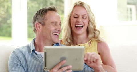 Joyful Couple Laughing Together Using Tablet at Home - Download Free Stock Images Pikwizard.com