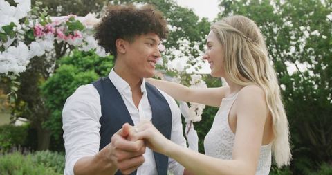 Happy Diverse Couple Dancing in Garden at Wedding