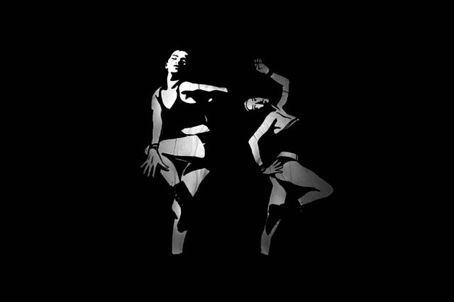 Black and white abstract depiction of two dancers mid-performance, emphasizing movement and form. Ideal for use in artistic publications, contemporary dance promotions, or modern art collections. Could also be used in designs involving creativity, motion, and performing arts themes.
