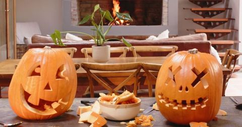 Cozy Living Room with Carved Pumpkins and Inviting Fireplace - Download Free Stock Images Pikwizard.com
