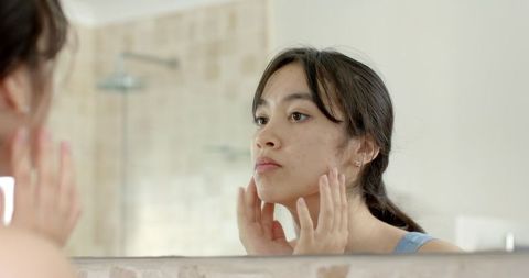 Woman Inspecting Skin in Bathroom for Skincare Routine