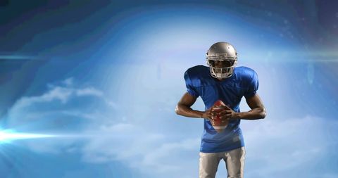 Confident American Football Player with Ball Against Sky