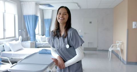 Smiling Female Doctor in Hospital Ward Confidently Standing