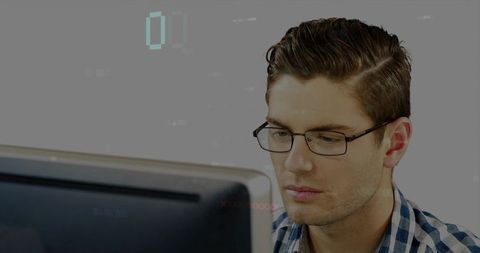 Focused professional at desktop wearing glasses, blue checked shirt, tech analytics concept