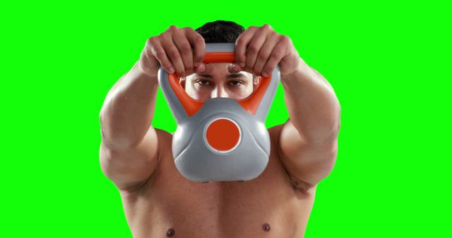 This image depicts a muscular man exercising with a kettlebell on a green screen background. The focus is on his training and physical strength. Ideal for fitness-related content, gym advertisements, workout blogs, and instructional materials. The green screen background allows for easy editing and integration into various multimedia projects.