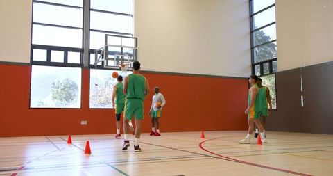Diverse Male Basketball Team Practicing Drills on Indoor Court