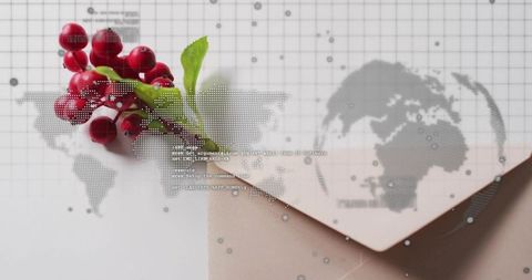 Red berry sprig lying on pale envelope with dotted world map overlay minimal flatlay