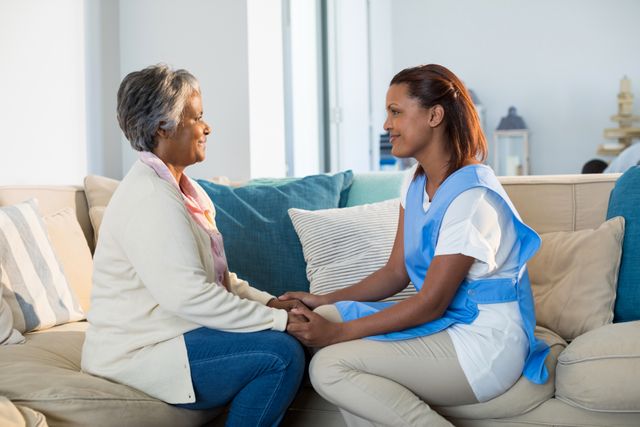 Female doctor comforting senior woman in living room - Download Free Stock Photos Pikwizard.com