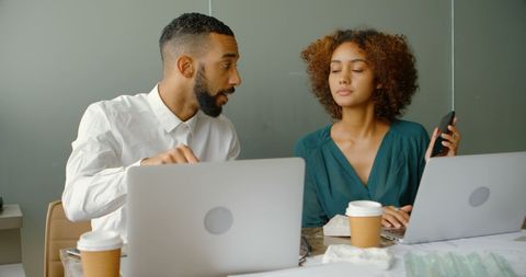 Colleagues Collaborating on Office Project with Laptops and Coffee
