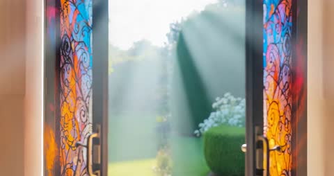 Sunlight Filtering Through Stained Glass Doors to Lush Garden