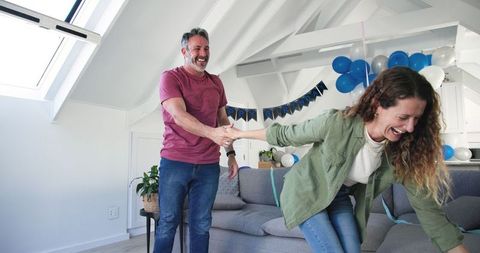 Couple Celebrating Joyful Birthday at Home With Balloons and Decorations