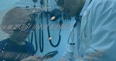 Doctor teaching child with digital overlay in medical room