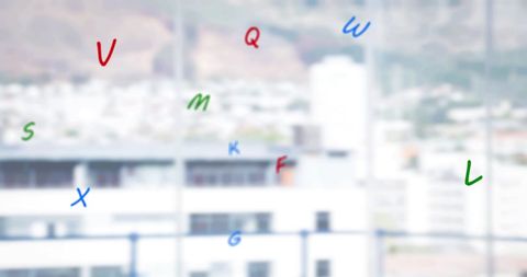 Floating colored letters over blurred urban landscape