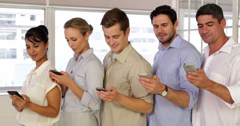 Multiracial Business Team Interacting with Smartphones in Modern Office