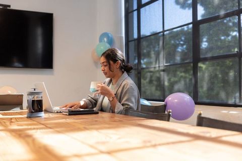 Asian Businesswoman Typing on Laptop in Bright Modern Meeting Room
