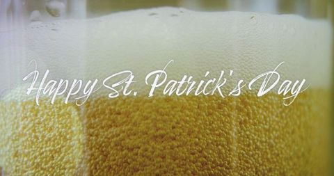 Closeup golden pint with dense bubbles and creamy foam head for st. Patrick's day
