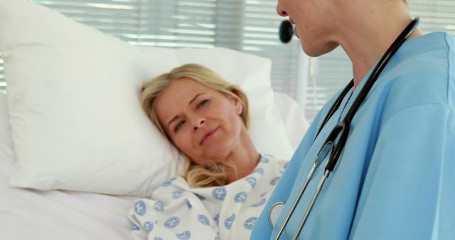 Nurse engaging with a recovering patient lying in a hospital bed, promoting care and communication in a healthcare setting. Suitable for health-related content, patient care illustrations, and medical industry promotions.