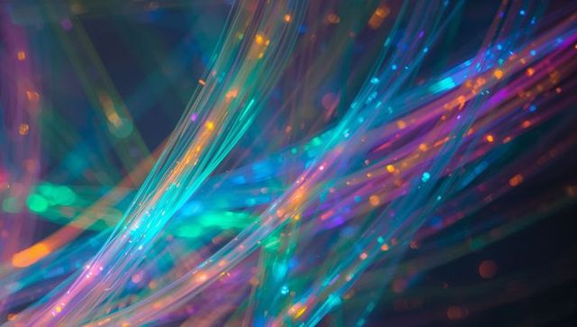 Neon fiber optic strands creating iridescent light trails and vibrant multicolor bokeh