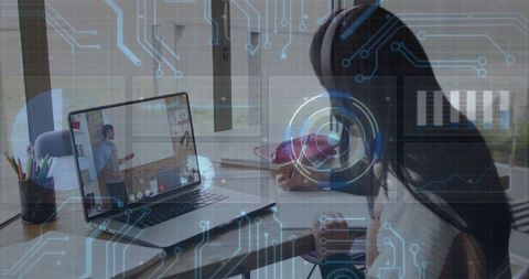 Teen writing and learning remotely wearing headphones with laptop and futuristic hud