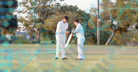 Cricket coaching two players adjusting bat grip on grassy field with turquoise helix overlay